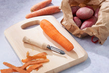 Load image into Gallery viewer, Carrots on a cutting board with a peeler, next to a bag of potatoes. | Hadley Green Home
