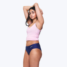 Load image into Gallery viewer, A woman modeling a light pink cropped camisole and navy blue briefs with 'WUKA' printed on the front, posed against a solid light gray background | Hadley Green Home