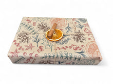 Load image into Gallery viewer, Gift box wrapped in floral-patterned paper with an orange slice and cinnamon stick on top. | Hadley Green Home

