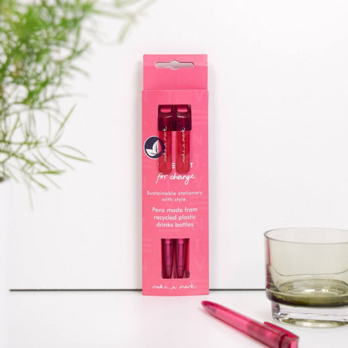 Pink packaging of pens made from recycled plastic bottles with a plant and glass in the background. | Little Twidlets