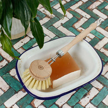 Load image into Gallery viewer, Wooden dish brush and soap bar in a white dish on a tiled floor with a plant.  | A Slice Of Green | Hadley Green Home
