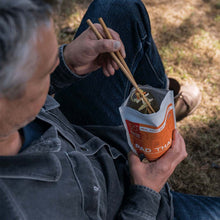 Load image into Gallery viewer, Person eating Pad Thai from a portable container outdoors | Little Twidlets
