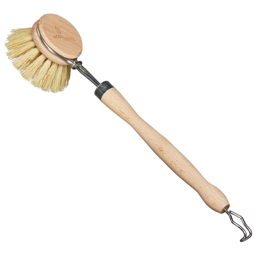 A wooden dish brush with a round bristle head and a long handle, featuring a metal clip at the end of the handle.