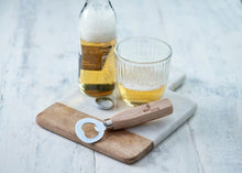 Load image into Gallery viewer, Bottle of beer, glass, wooden cutting board with bottle opener on a light surface | Hadley Green Home
