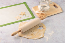 Load image into Gallery viewer, Rolling pin with star-shaped cookie cutter on dough next to a green pastry mat and jar of flour | Hadley Green Home
